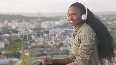 可爱的非裔美国<strong>女孩听音乐</strong>，微笑。 美丽的黑人<strong>女孩</strong>户外城市景观背景