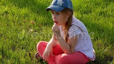 <strong>小女孩</strong>坐在<strong>草地上</strong>吃冰淇淋。