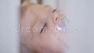 一个小女孩睡在婴儿床上，嘴里放着奶嘴