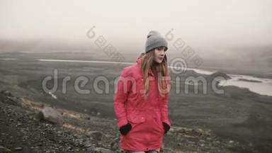 年轻迷人的女人独自走在火山黑山里。 游客探索冰岛，去冰湖。