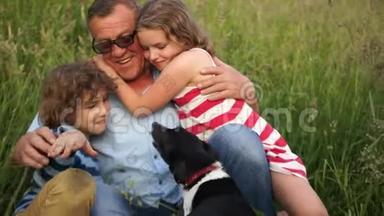 卷曲的男孩和女孩在夏天的空地上玩得很开心，而不是和祖父和他们的宠物狗在一起。 夏季