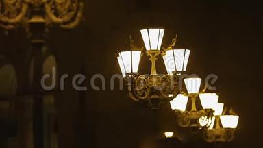 老式的街灯照亮了人们夜间行走的城市道路