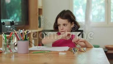 坐在桌边用<strong>彩色铅笔画</strong>画的小女孩
