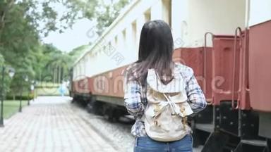 4K镜头。 快乐的亚洲旅游妇女在火车站，走到火车上，走上楼梯。 乘老式火车在亚洲旅行。