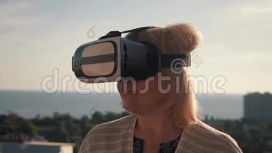 太阳落山时，一个戴着虚拟现实眼镜的女孩在房子的屋顶上。 生命生命概念