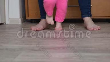 孩子和母亲的腿赤脚踩在地板上