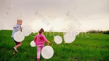 两个小女孩在一起玩得很开心-带着球在球场上跑来跑去。 其中一个跌跌撞撞。 开心快乐