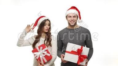 慢动作的年轻夫妇穿着毛衣，喜欢和礼物一起跳舞，一起庆祝圣诞节，一起感受吸引力。