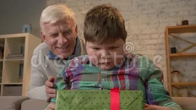 祖父给他孙子一份礼物。 老人送礼物给胖孩子.. 快乐，惊喜，快乐，情感