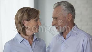 年老的男人和女人互相看着，把头<strong>放在一起</strong>，家庭和睦