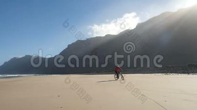 年轻人骑自行车在加那利群岛的沙滩上。 兰萨罗特，大西洋。
