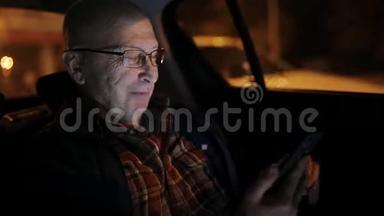 一个在车里用手机的老人。 他在网上发短信、查看邮件、聊天或新闻。 <strong>晚安</strong>。