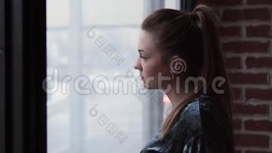 悲伤的女孩望着窗外，转过头来