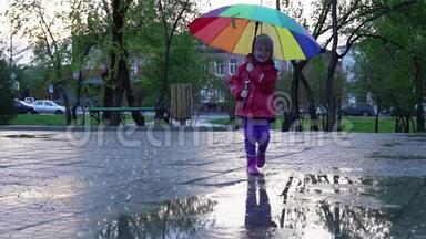 日落时分，可爱的小女孩带着五颜六色的雨伞在公园的水坑里奔跑