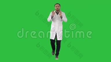 开朗的医生走路，说话，看着相机上的绿色屏幕，铬键。