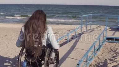 在春季或秋季，坐轮椅的残疾青年妇女在靠近海洋的斜坡旁为<strong>残疾人</strong>移动