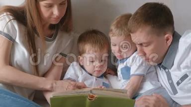 一家人的爸爸妈妈和两个<strong>双胞胎兄弟</strong>躺在床上看书。 家庭阅读时间。
