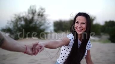 浪漫的概念，年轻的夫妻，双手赤脚在沙滩上奔跑，女人牵着爱人的手，向前奔跑