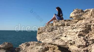 一个年轻的女人在岩石上晒太阳。