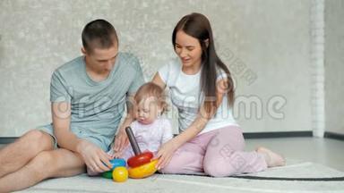 快乐的一家人在家玩。 一家人坐在地板上一起玩耍