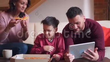 家庭在客厅吃披萨时使用数码平板电脑