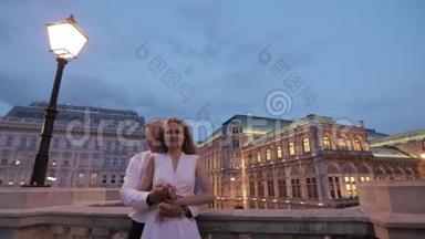 幸福的一对夫妇晚上在城里散步。 维也纳，奥地利。 <strong><strong>歌剧</strong>院</strong>附近的看台
