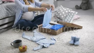 怀孕妈妈打开婴儿衣物礼品盒