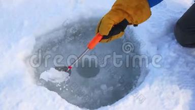 渔人之手为<strong>冬季捕鱼</strong>从冰中清理潜洞