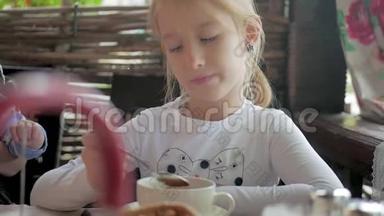 可爱的小女孩在咖啡馆喝茶。 <strong>清淡</strong>的早餐。 小白种人女孩在咖啡馆喝茶。