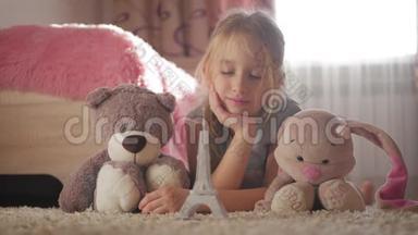 小女孩带着她的玩具在儿童房梦想着去巴黎旅行。 童梦，度假和旅游理念..