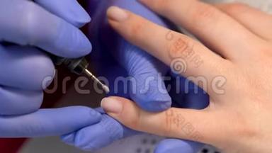 用铣甲机进行指甲角质层去除和指甲抛光的特写. 五金修指甲