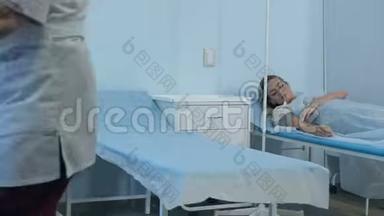 两名女病人躺在医院病房的病床上，由两名医生检查