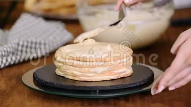 在家里做一层一层的拿破仑蛋糕：把奶油蛋糕放在烘焙的糕点上。