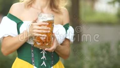 在一位身着国服的年轻女服务员<strong>手中</strong>，特写一杯巴伐利亚啤酒。 音乐节