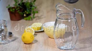 用柠檬和薄荷在一个小厨房的玻璃瓶中准备柠檬水。