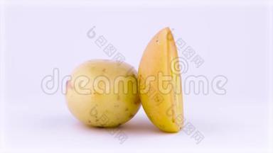 一个完整的和一个半切成熟的<strong>黄色</strong>佩皮诺水果旋转在<strong>转盘</strong>上。 孤立于白色背景