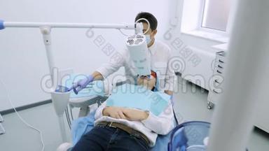 女士在牙科医生办公室用紫外线`机器进行紫外线美白.