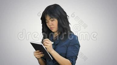 亚洲女人在白色背景的记事本上做一些笔记
