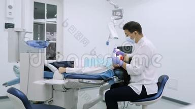 女士在牙科医生办公室用紫外线`机器进行紫外线美白.
