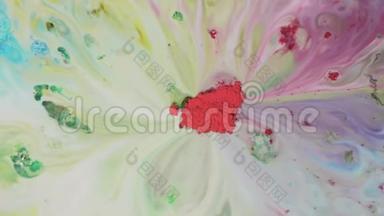 彩色粉末涂料在水中混合.. 中间的红色粉末的特写可以吸收牛奶表面五颜六色的洗液