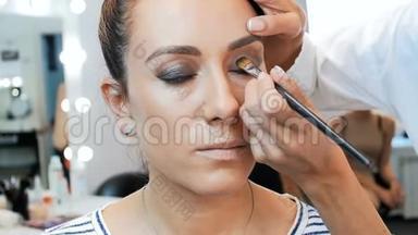 专业化妆师在工作室工作的特写慢镜头视频。 形象设计师在模特脸上化妆