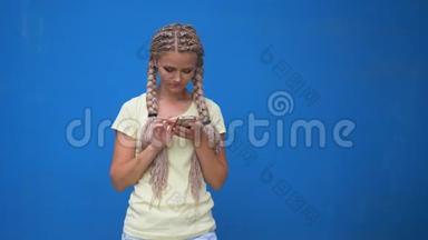 欢快可爱的年轻女学生留着辫子、扎着辫子、留着发式用手机聊天的照片