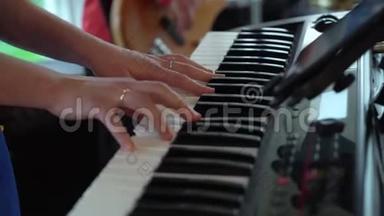 音乐家演奏电子键盘合成器钢琴。 乐队在音乐会舞台上演奏音乐