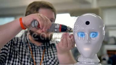 一个人用工具固定机器人`头部。