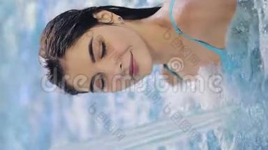垂直视频。 年轻女子在游泳池里享受水。 水上有氧运动。 移动设备垂直框架