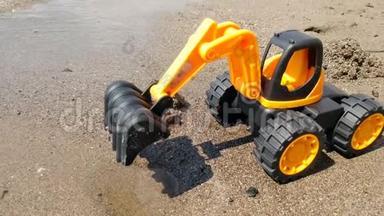 玩具<strong>橙色</strong>挖掘机站在沙滩上的特写4k<strong>视频</strong>