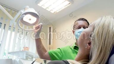 牙科医生调节灯和看病人坐在椅子上的4k特写镜头
