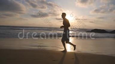 男运动员在户外运动。 日出时，运动员沿着海岸慢跑。 年轻的运动健将