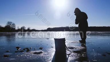 冬季捕鱼。 冬天阳光明媚的一天，湖上的渔夫。