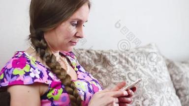 坐在沙发上看手机的女人